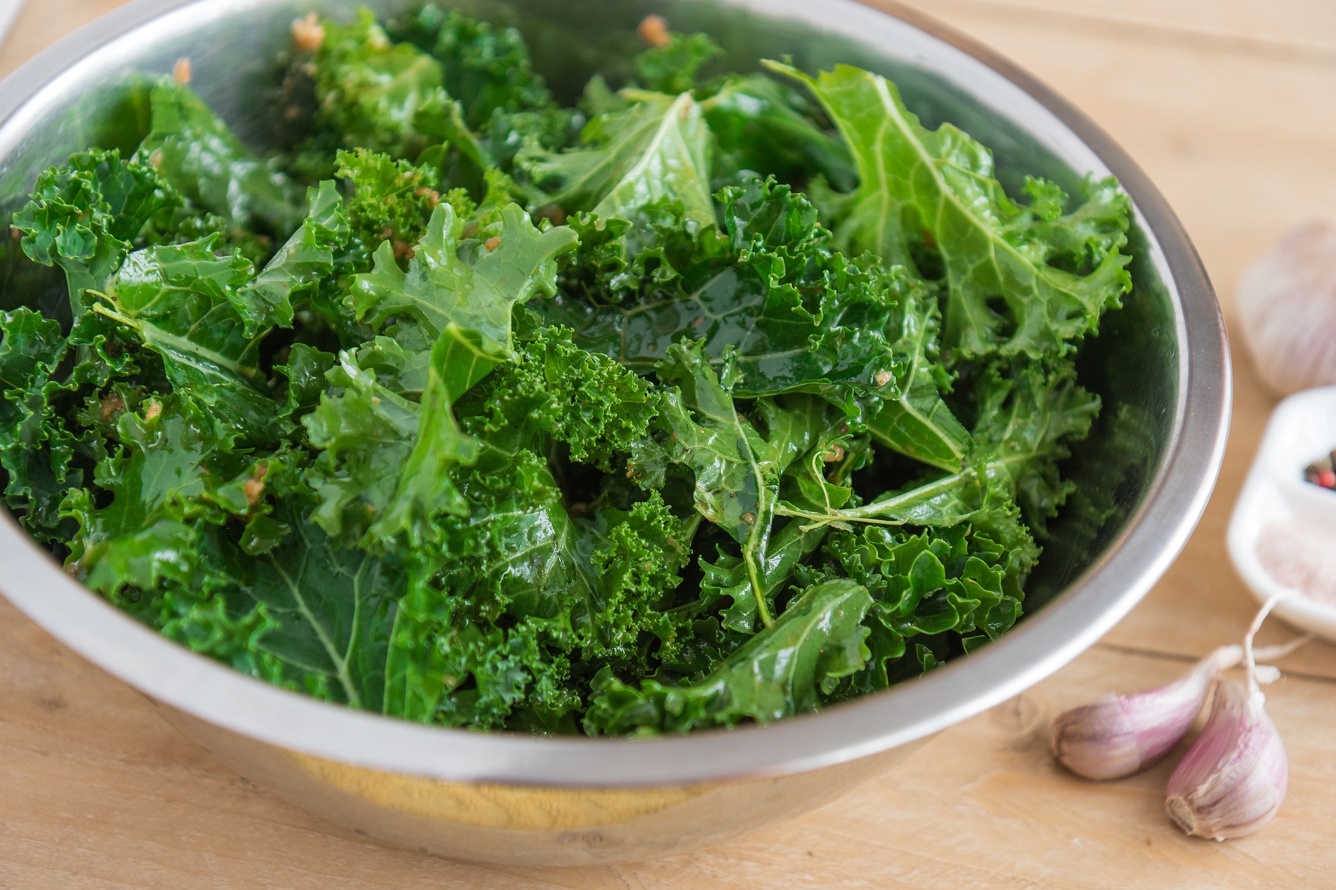 photo with kale in a bowl and cloves of garlic