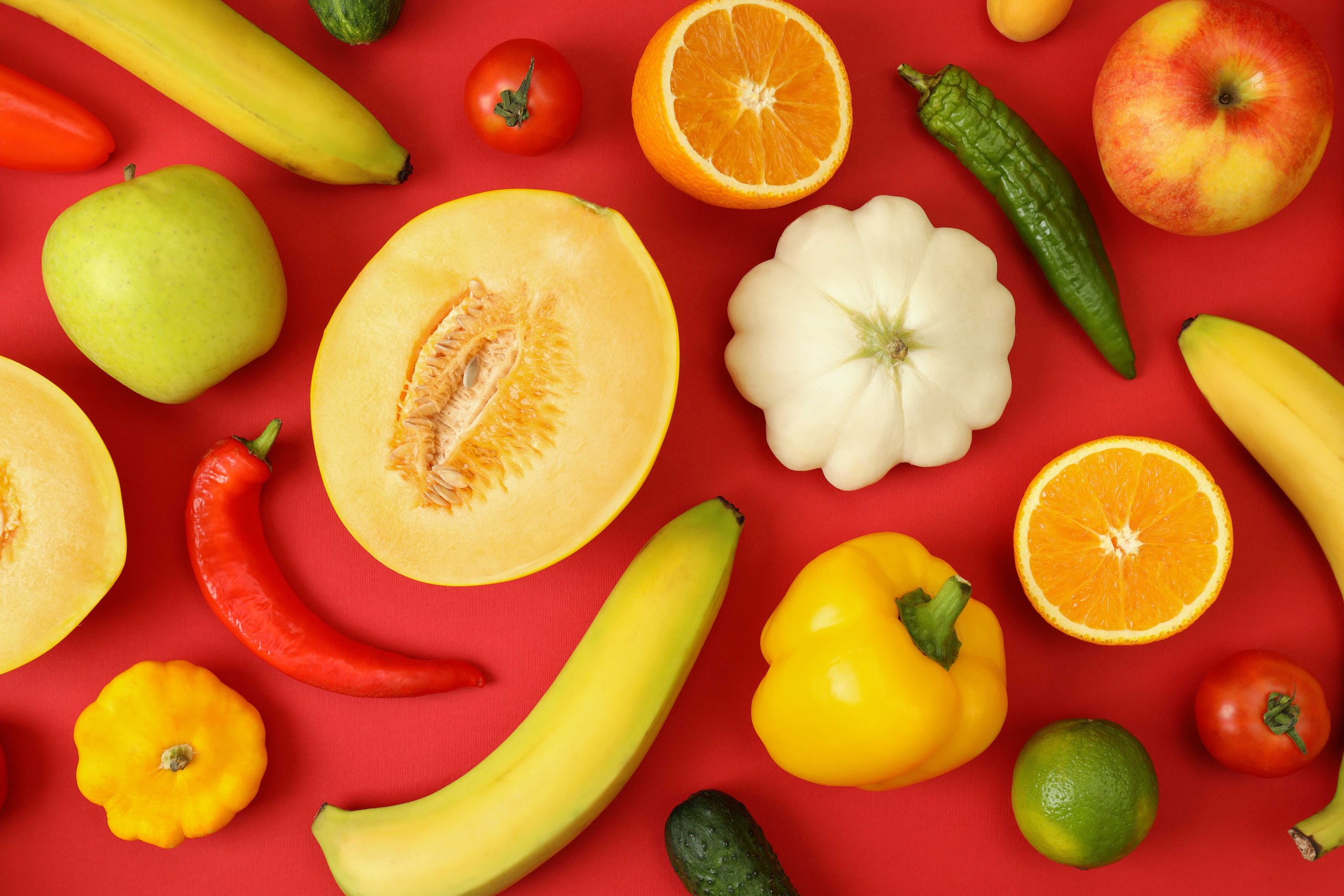 Set of different vegetables and fruits on red background