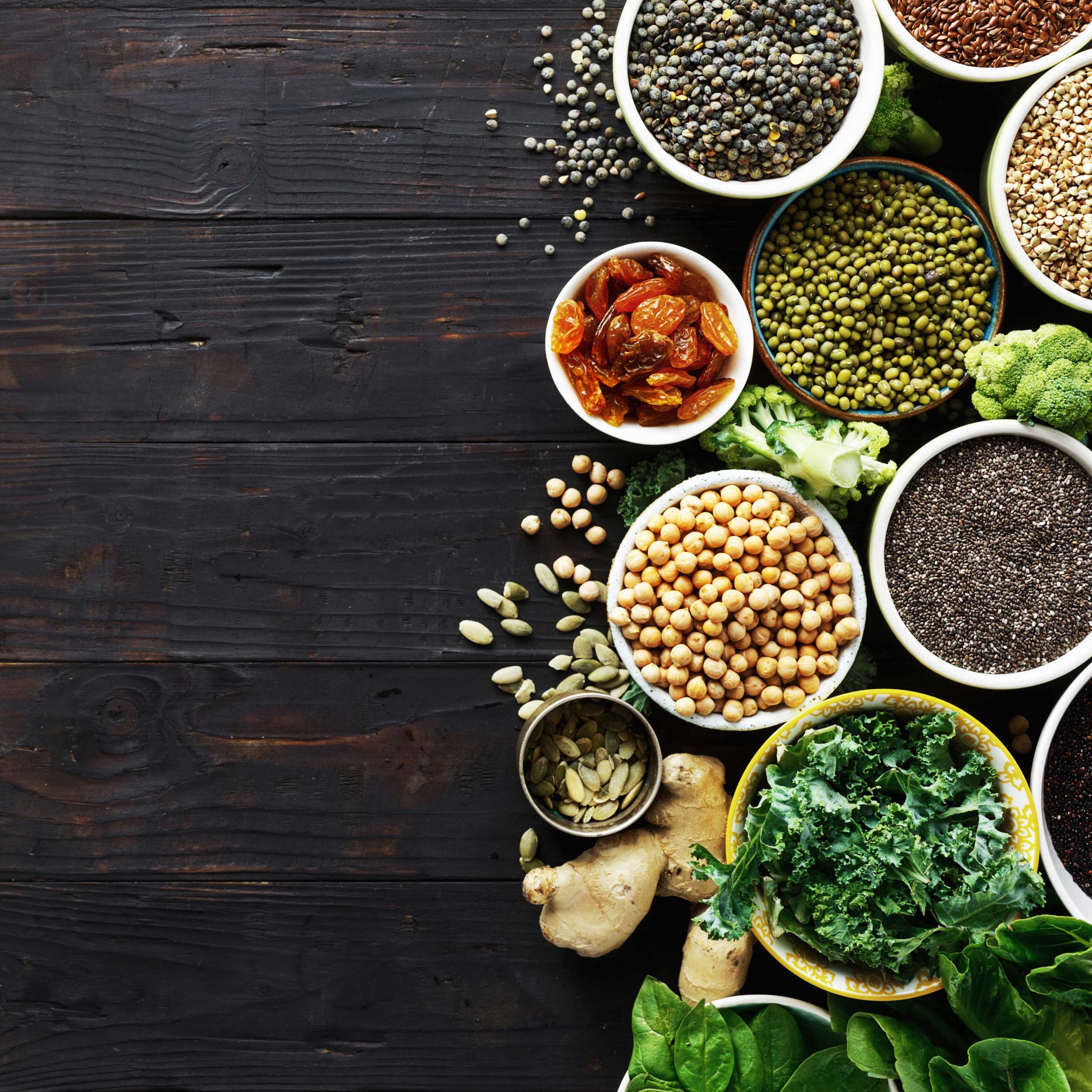Super food or vegetarian food concept. Seeds, cereals, beans, vegetables, herbs for healthy cooking on dark wooden background top view with copy space